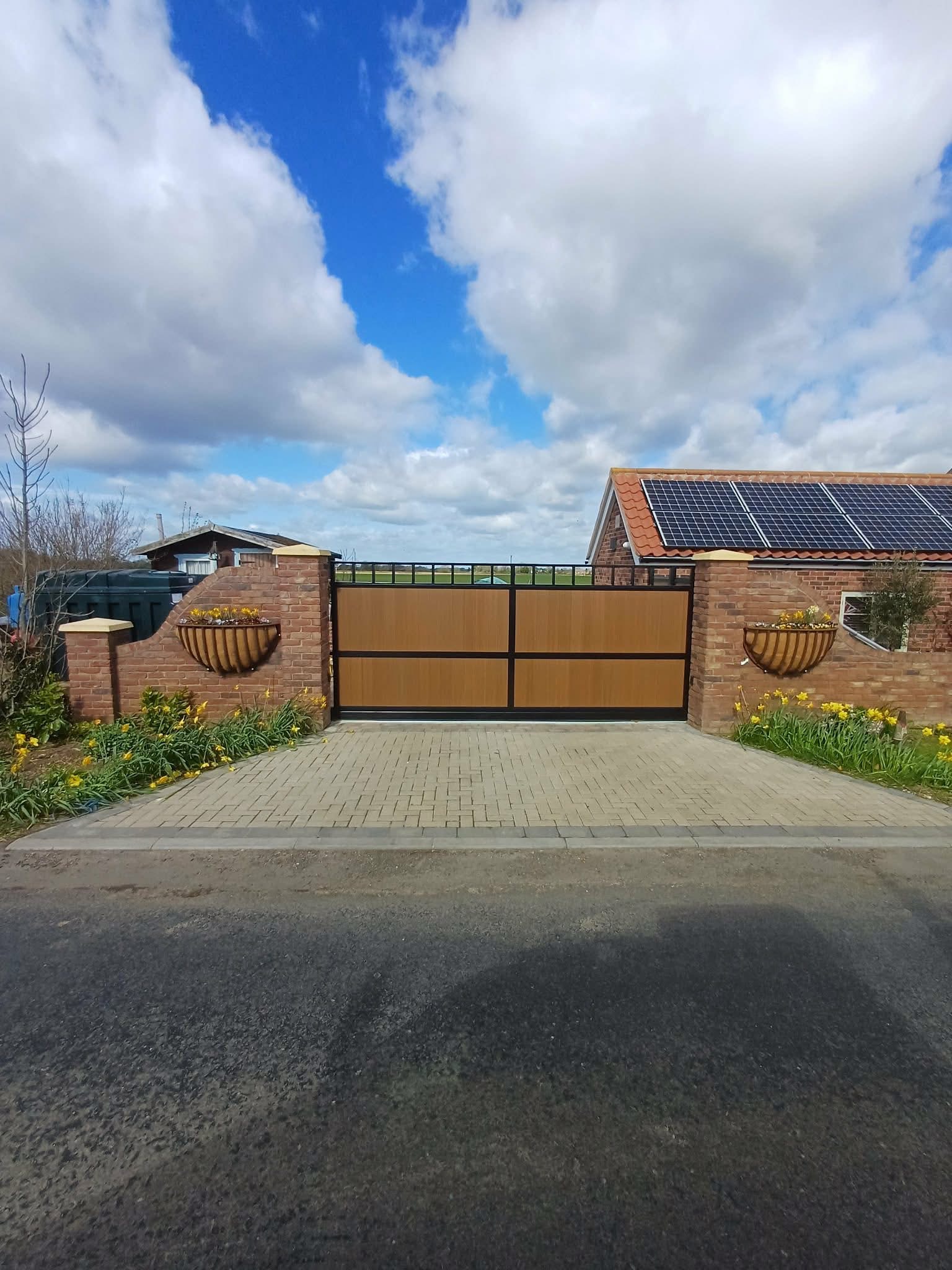 Block-paved entrance with a gate and brick boundary walls
