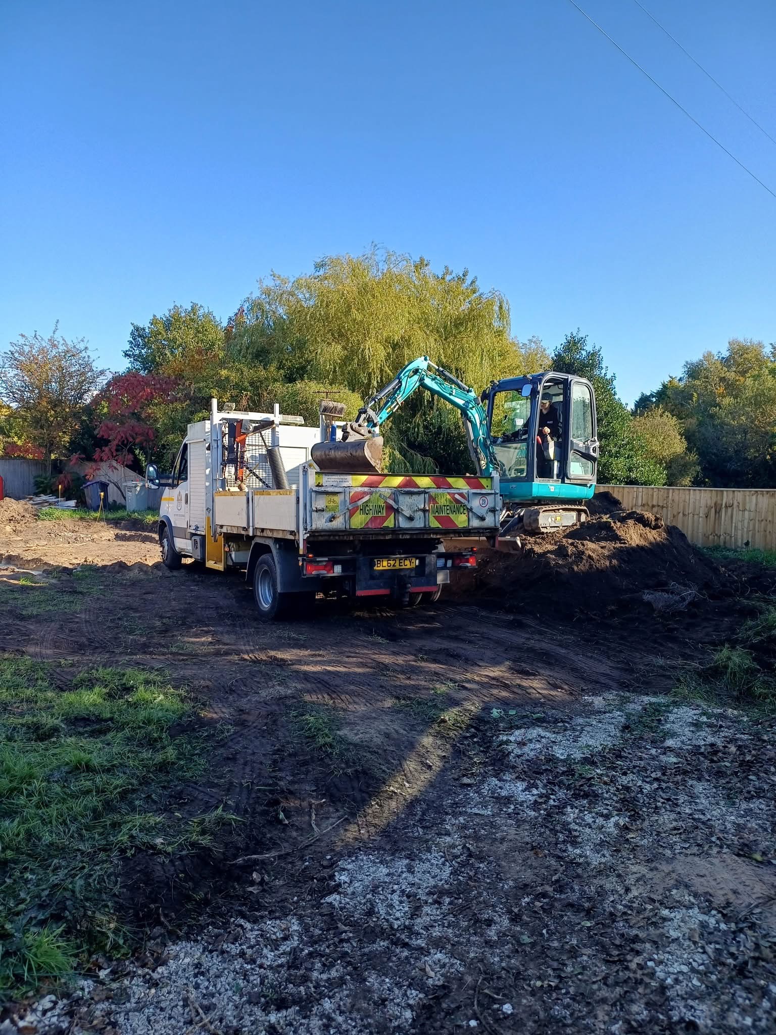 Mini excavator loading a tipper truck on an excavated site